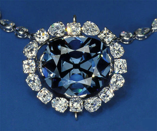 Close-up of a stunning black diamond pendant surrounded by sparkling white diamonds, set in a luxurious necklace with a blue background.