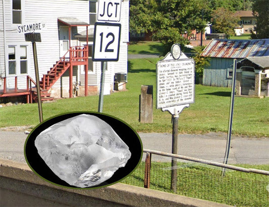 Scenic view of a small town with a historical landmark sign and a clear quartz crystal inset in the foreground, showing the junction of Sycamore St and Highway 12.