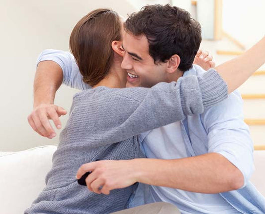 Couple embracing each other in a joyful and intimate moment, celebrating a special occasion with a happy expression.