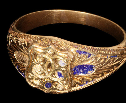 Vintage gold ring with intricate engraving and lapis lazuli inlays, featuring a shield design.