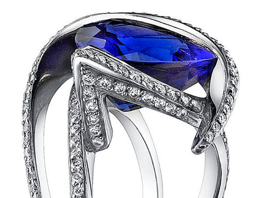 Close-up of an elegant sapphire ring with diamond accents, featuring a modern design with intricate detailing.