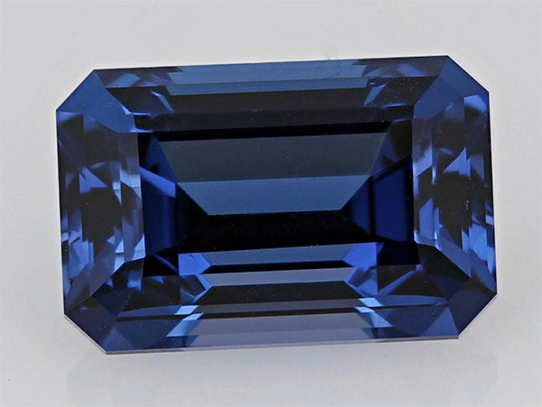 Blue sapphire gemstone with an emerald cut, featuring deep blue hues and excellent clarity, perfect for fine jewelry designs.