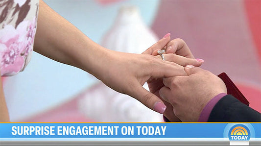 Close-up of a surprise engagement on the Today show, showing a person proposing with a sparkling diamond ring, capturing a joyful moment between the couple.