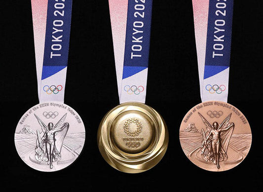 Tokyo 2020 Olympic gold, silver, and bronze medals displayed with ribbons.