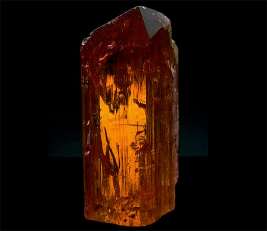 Close-up image of a natural amber crystal with a rich orange hue, showcasing its intricate texture and sharp edges.