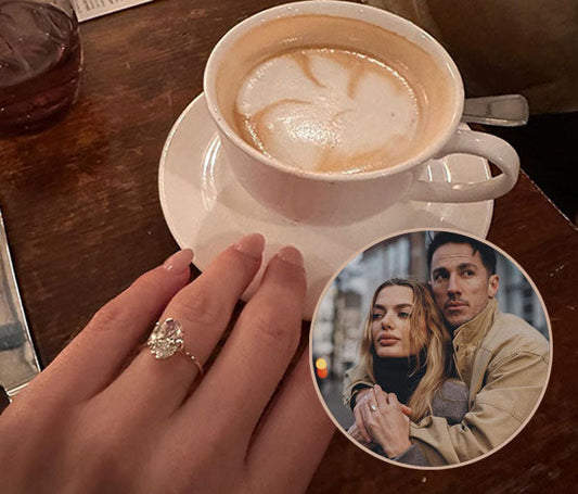 Close-up of a hand with an engagement ring holding a cup of coffee, with an inset photo of a couple embracing in a romantic pose.