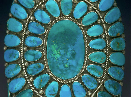 Close-up of a turquoise jewelry piece featuring multiple oval turquoise stones set in a silver frame.